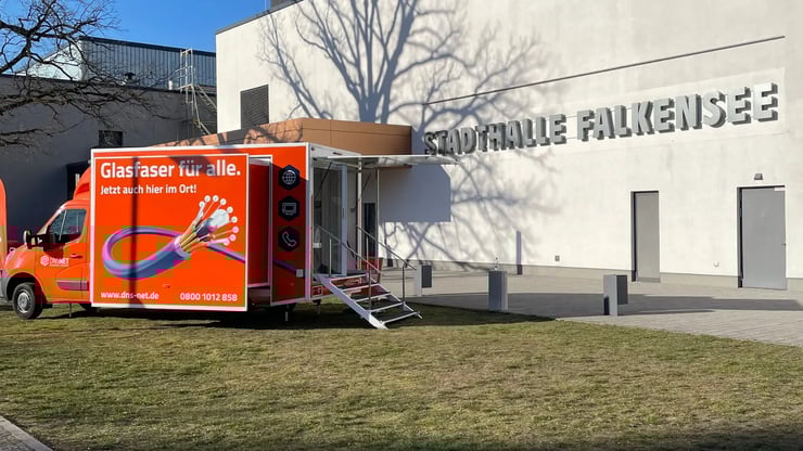 DNS:NET Infomobil vor der Stadthalle Falkensee – Einladung zur Glasfaser-Infoveranstaltung für Bürgerinnen und Bürger.